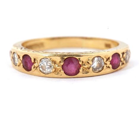 A 9ct ruby and diamond ring, set with graduated alternating rubies and diamonds, channel set with engraved decoration to side