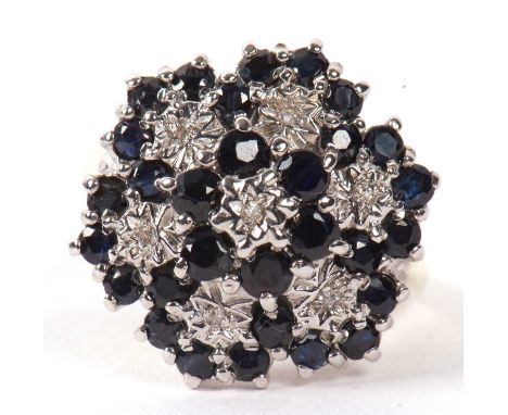 A 9ct sapphire and diamond cluster ring, the flowerhead design set with illusion set diamonds and small round sapphires, all 