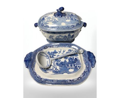A blue and white transfer printed willow pattern soup tureen with ladle, on stand, width 40 cm.