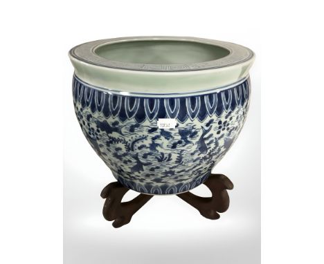 A reproduction Chinese blue and white porcelain fish bowl planter on stand, height 36 cm.