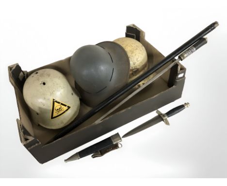 A reproduction swordstick, German dagger and three helmets.