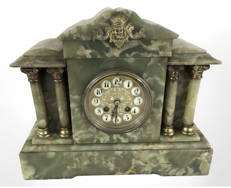 An onyx and gilt metal eight day mantel clock with enameled dial, height 30 cm.