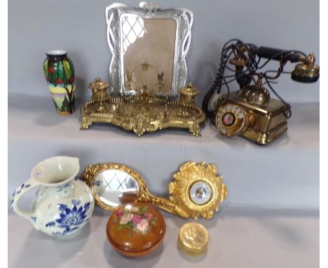 A miscellaneous collection of items including an elaborate brass desk stand, a brass vintage telephone, an ornate brass desk 