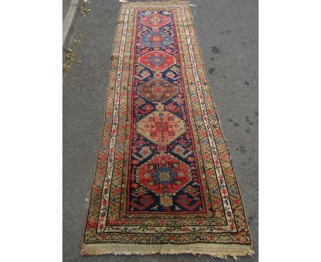 An Kazak design runner with a row of six gul to the centre 300cm x 95cm approx 