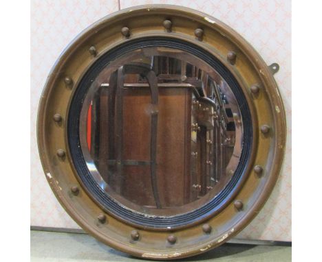 An antique Regency style circular wall mirror with bevelled edge plate, ebonised slip and gilt ball surround, 64cm diameter 