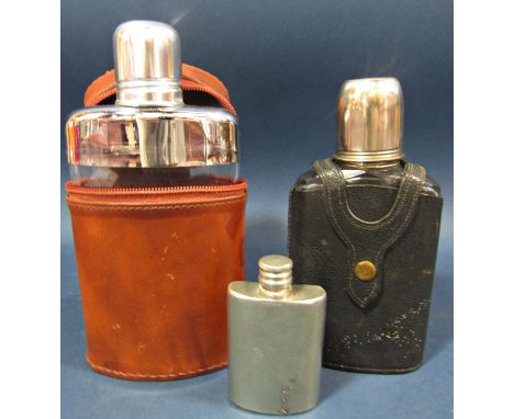 A brown leather clad hip flask with a silver  plated top and toddy cup, another similar with a black leather cover and a smal