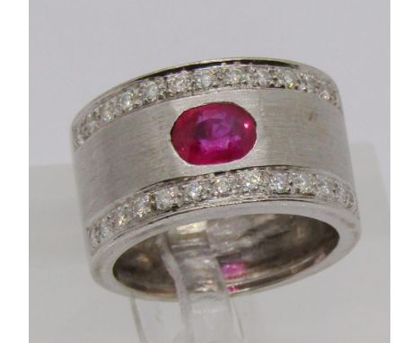 18ct white gold band ring set with an oval ruby and two rows of diamonds, size K/L, 8.9g 