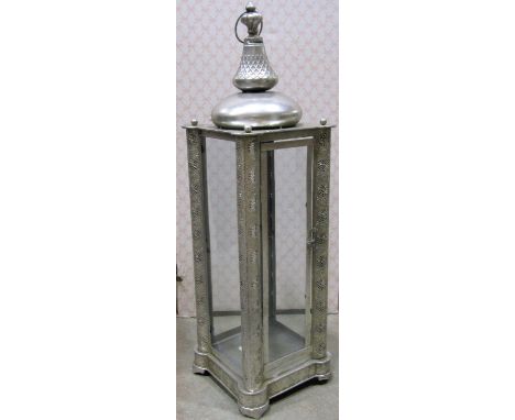 A pair of contemporary Moroccan style tall light metal hanging ceiling lights enclosed by glazed panels flanked by decorative