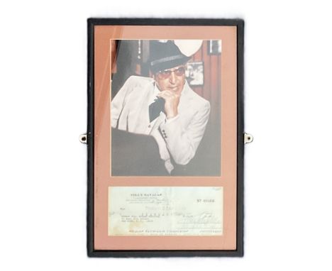 Telly Savalas Signed cheque 15/02/1977, with colour photo. Framed. Measures 11 inch by 16-inch appx. Good Condition. All auto