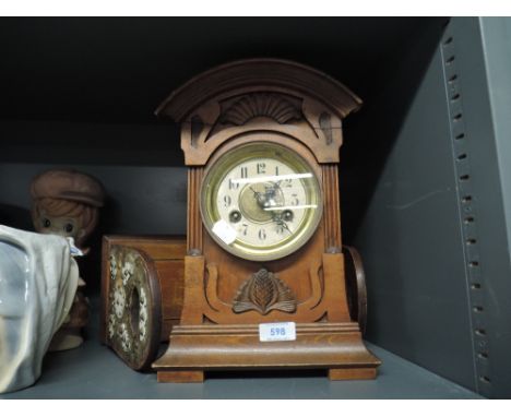 A mahogany cased, enamel faced mantle clock and sliding book stand