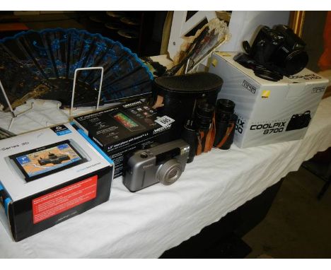 A boxed Nikon camera, a boxed Satnav, binoculars etc.,