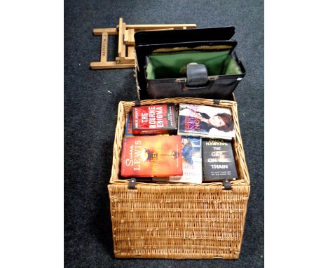 A wicker hamper containing assorted books together with a box containing artist's easel, brushes etc 