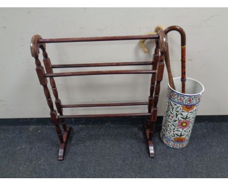 A wooden clothes airer and a ceramic stick pot with three walking sticks 