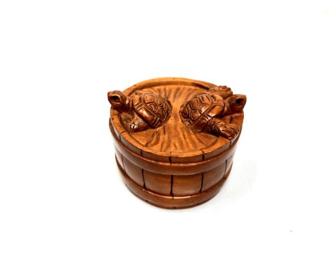 A carved hardwood Chinese netsuke - Two turtles in a barrel 