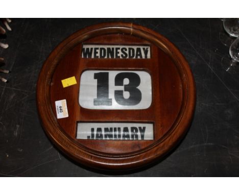 A late 19th century mahogany circular manual calendar with three apertures 