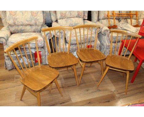A set of four Ercol light elm seated spindle back chairs (used), bearing Ercol label to underside 