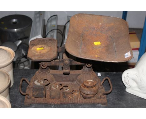 A set of balance scales, with four graduating weights and three associated, corroded throughout  