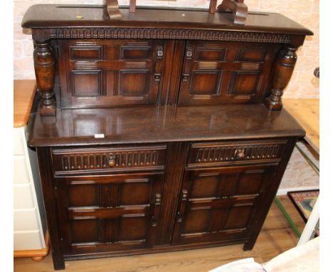 A reproduction oak court cupboard in the manner of Ercol or Priory  