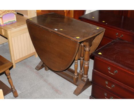 An oak drop leaf and gate leg table raised on turned legs