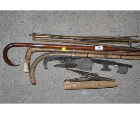 A bundle of three vintage walking sticks, one with silver collar, a metal music stand and two ice skate blades