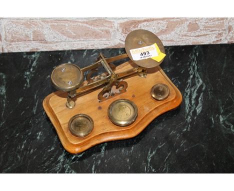 A set of 19th century postal scales with three weights, the base of serpentine form  