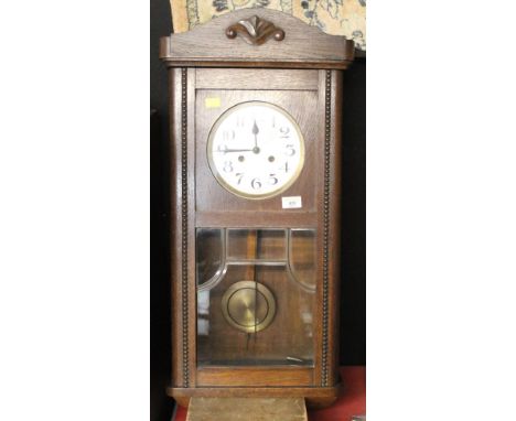 A 1930's oak wall clock, with Arabic hours and bead moulding