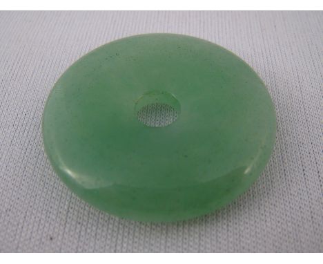 A jade disc pendant, approx 3cm diameter, 8.9 gms.