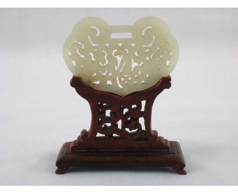 A fine Chinese jade carving, 7x5cm., with pierced hardwood stand.