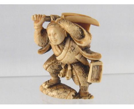 A stained ivory netsuke of a warrior, ht. 5cm. Circa 1920.