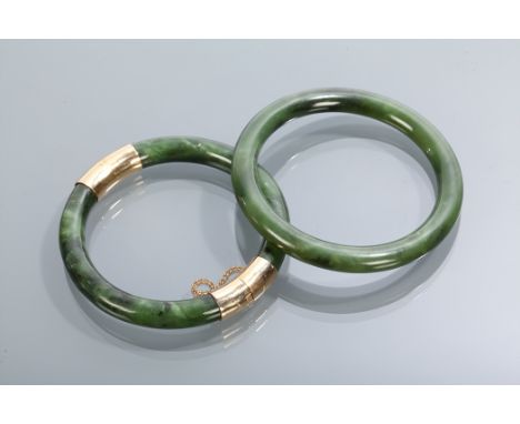 TWO CHINESE JADE BANGLES one with white metal mounts  