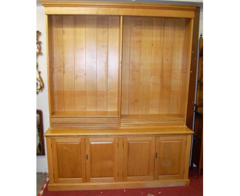 A large contemporary joined light oak freestanding open bookcase, the twin open upper compartments with adjustable shelves, o