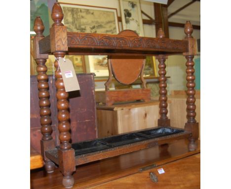 An early 19th century line carved oak twin division stickstand, raised on bobbin turned supports, width 76cm