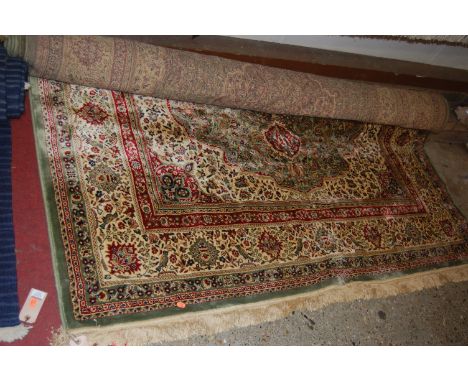 A Persian woollen Kashan carpet, having green ground and multiple trailing borders, w.195cm