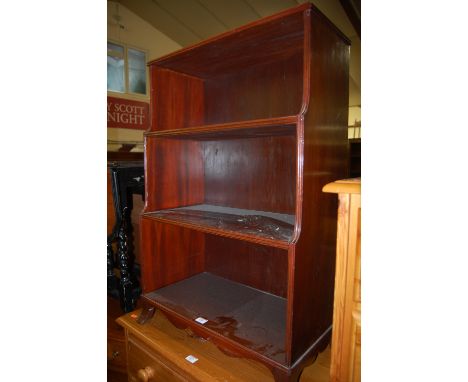 An early 20th century mahogany waterfall open bookshelf, with shaped apron and splayed bracket forelegs, width 60cm