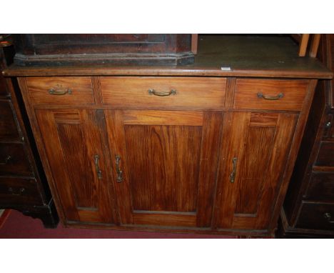 A 19th century stained pine and rexine inset side cupboard, having three frieze drawers over three conforming recessed panel 