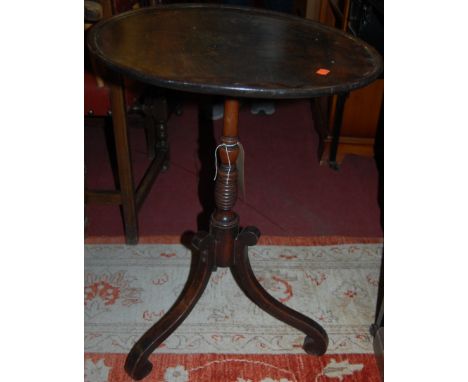 An early 19th century mahogany circular tilt top pedestal tripod table raised on ring turned honeycomb column to slender outs