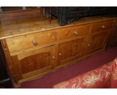 A Victorian style reclaimed pine round cornered dresser base, having three frieze drawers over three conforming recessed pane