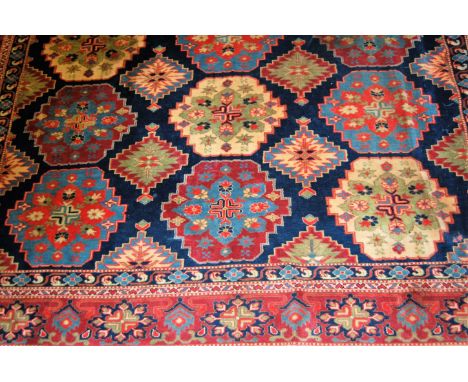 A Persian woollen blue ground carpet, decorated with interlocking medallions within trailing tramline borders, and having kel