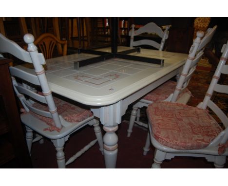 A contemporary cream painted and tile inset round cornered dining table, together with a matching set of four panelled seat l