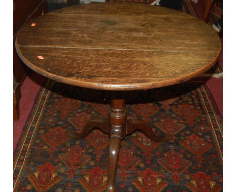 An early 19th century provincial oak circular tilt top pedestal tripod table, dia. 76cm
