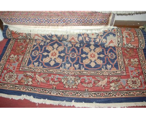 A Caucasian woollen blue ground carpet, having trailing tramline borders, w.177cm