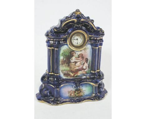 An Edwardian blue and gilt earthenware mantel clock, decorated with figures, 38cm high x 33cm wide