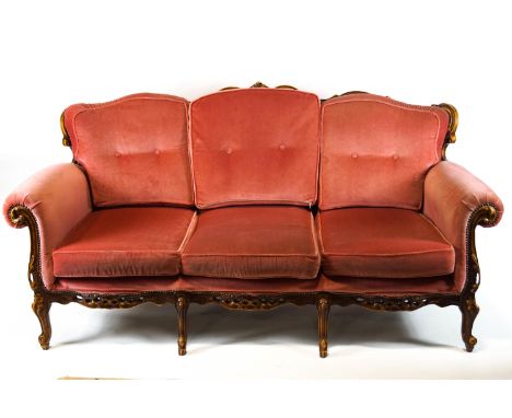 A French Rococo style mahogany framed three piece salon suite, comprising a three seater sofa, the outer frame carved and pie