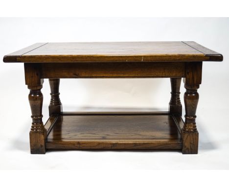 A period style elm coffee table with a three plank style top raised on turned legs on a solid base shelf, 45cm high x 96cm wi