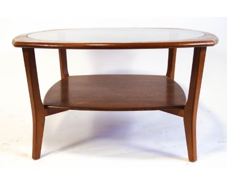 A G-plan style coffee table, the oval top with central glass panel, standing on four corner supports and solid base shelf, 46