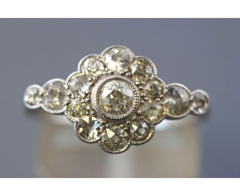 A white metal daisy cluster ring set with fifteen old European cut diamonds measuring from 2.00mm to 3.50mm diameter. Estimat