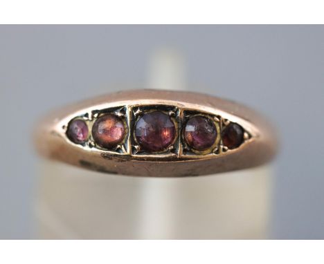 A rose metal half hoop ring set with five circular cabochon cut purple stones (Too worn to test definitively - Potentially rh