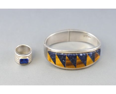 A Mexican white metal double hinged bangle, st with a panel of sodalite and tigers eye, and a broad five band style ring set 