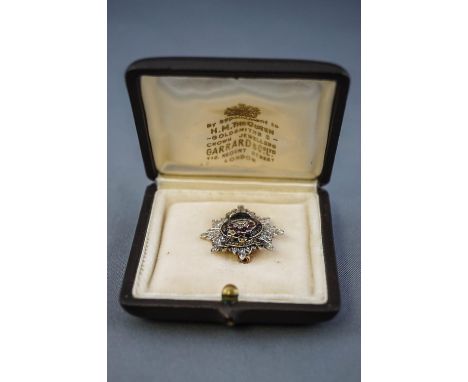 A yellow and white metal Hampshire regiment brooch. Centrally set with a ruby and rose cut diamond cluster together with a ro