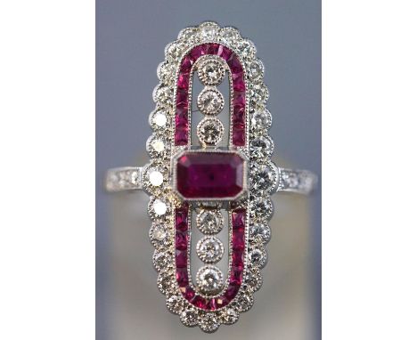 A white metal dress ring centrally set with a rectangular cut ruby measuring approximately 5.50mm x 4.00mm. Further set with 